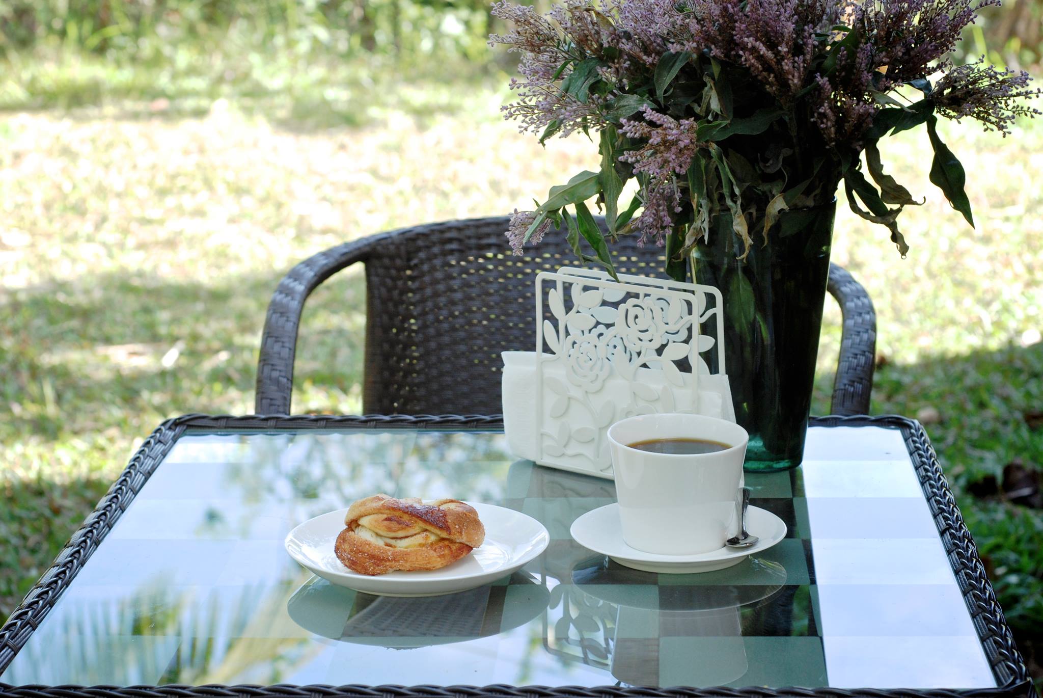 Coffee and pastry served on an outdoor table at Cinnamon Café and Bakery